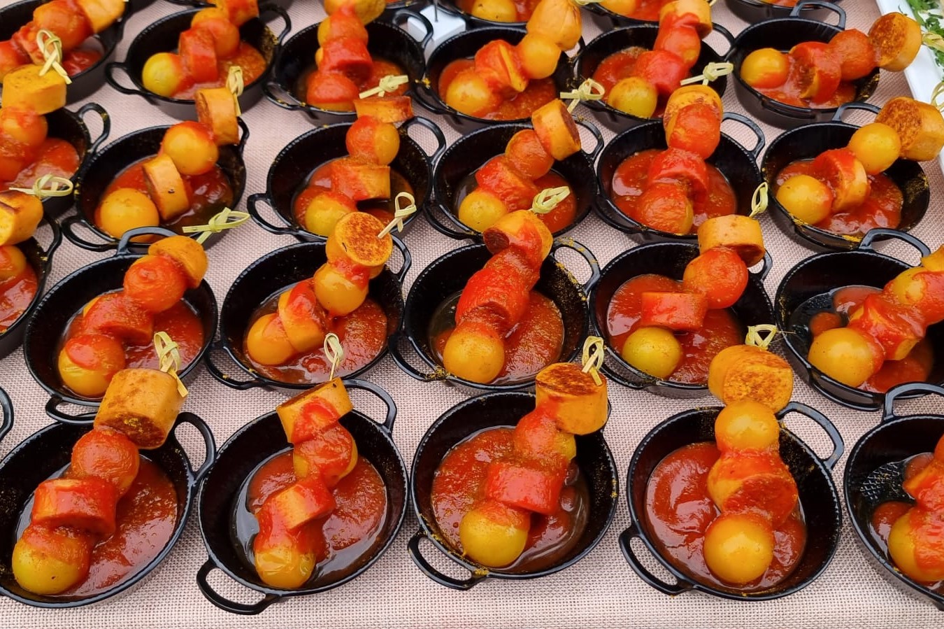 Currywurst und Tomaten auf einem Spießchen mit Currysauce